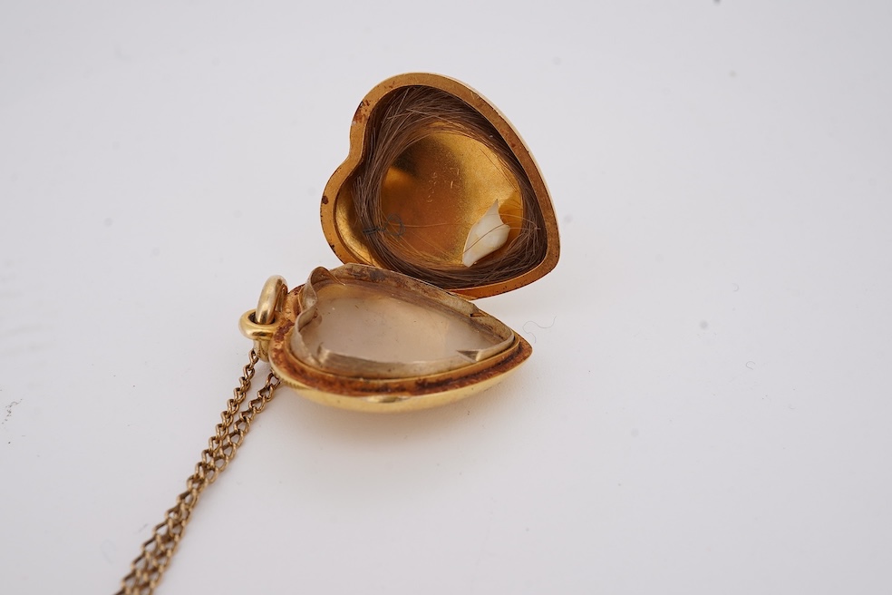 A modern embossed 9ct gold heart shaped locket, 21mm, on a similar 9ct gold rope twist chain, 46cm, together with one other yellow metal heart shaped locket, on a yellow metal chain, gross weight 14.5 grams. Condition -